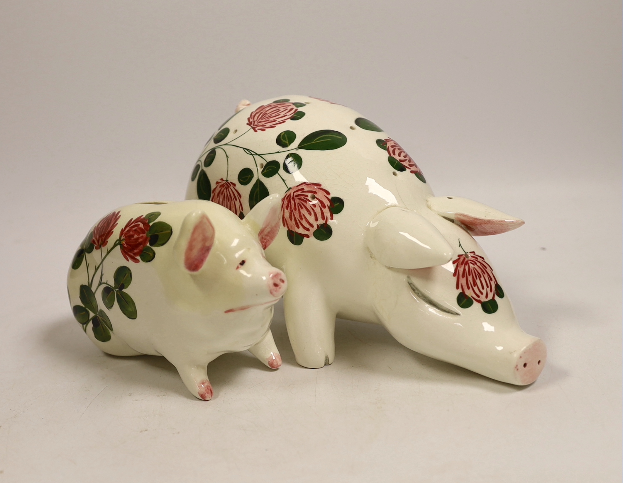 A Plichta rose decorated pig money box, 16cm, and a Plichta rose decorated hatpin holder pig, 23cm and two other Plichta pigs